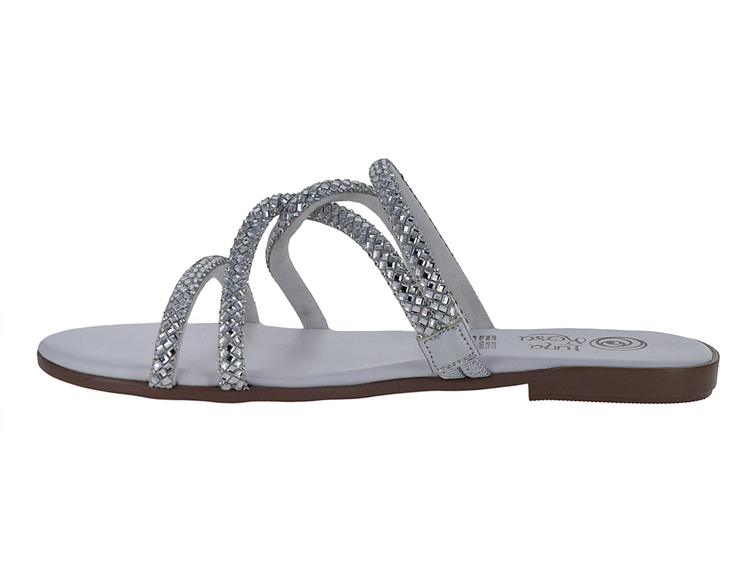Sandalia blanca y plata con tiras brillantes y suela plana.