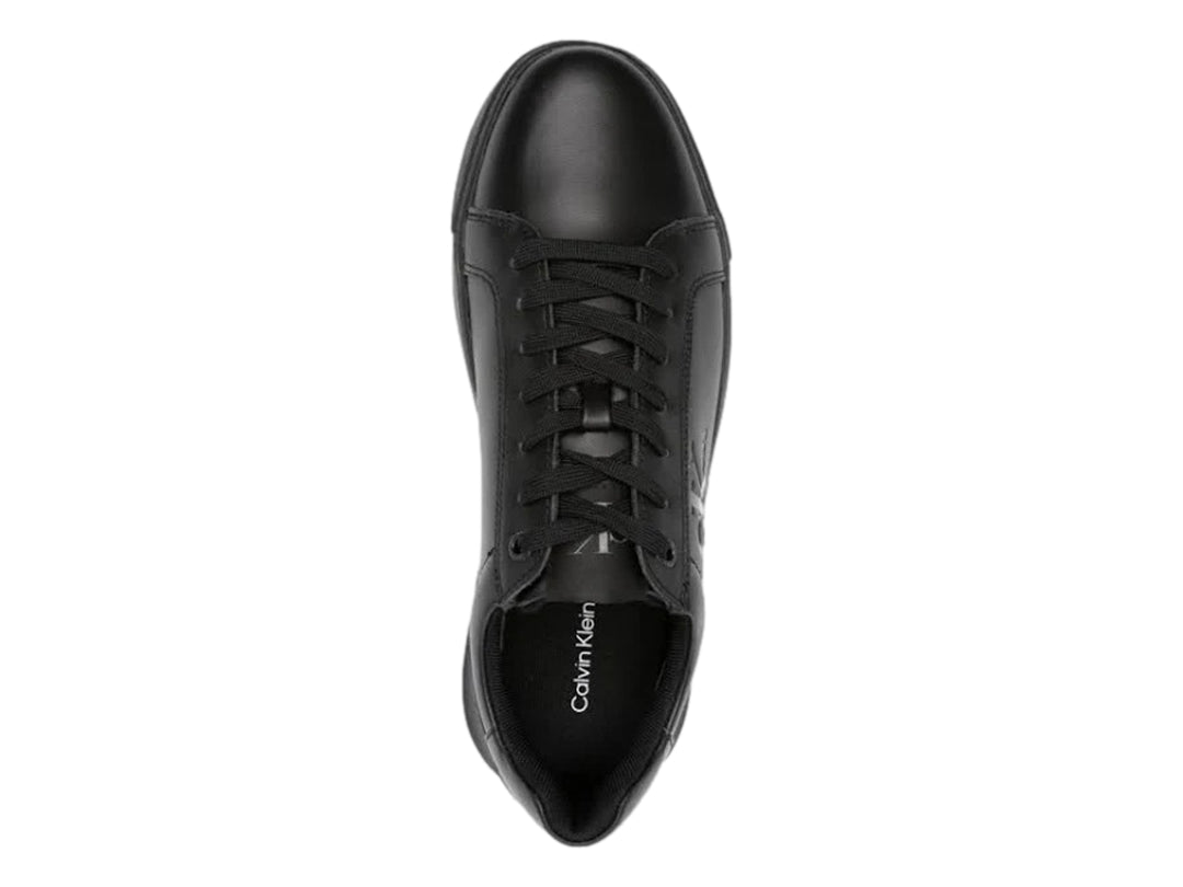Tenis negros de cuero marca Calvin Klein con suela chunky y agujetas negras.