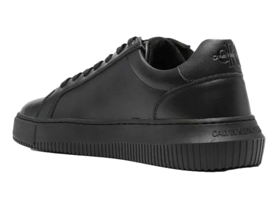 Tenis negros de cuero marca Calvin Klein con suela chunky y agujetas negras.