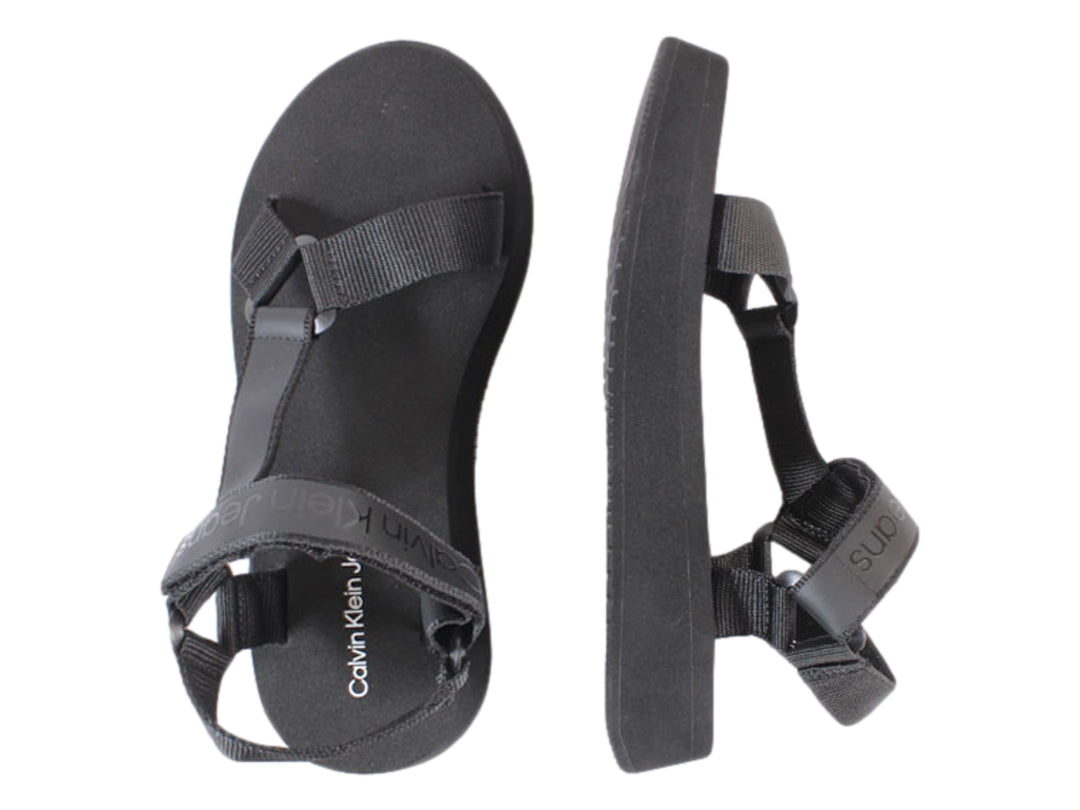 Sandalia de plataforma color negro con correas de velcro y suela gruesa.