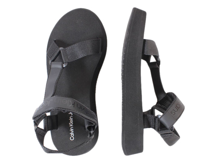 Sandalia de plataforma color negro con correas de velcro y suela gruesa.