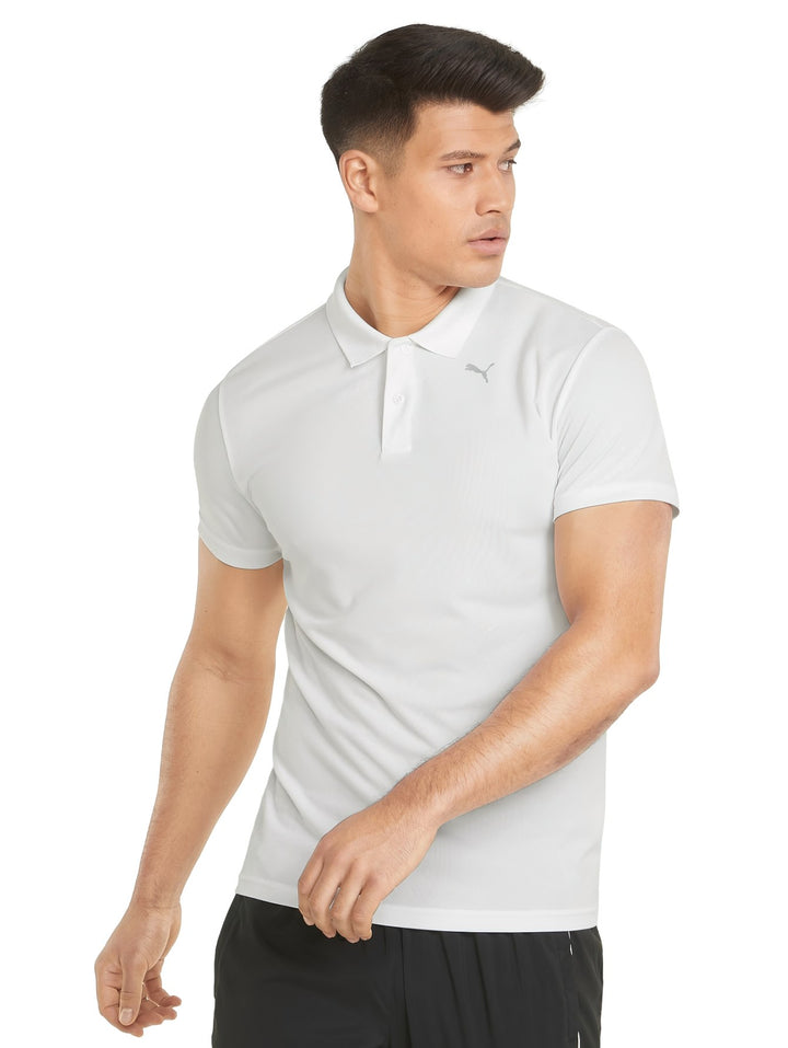 Hombre vistiendo una playera polo deportiva de color blanco marca PUMA con cuello y manga corta.