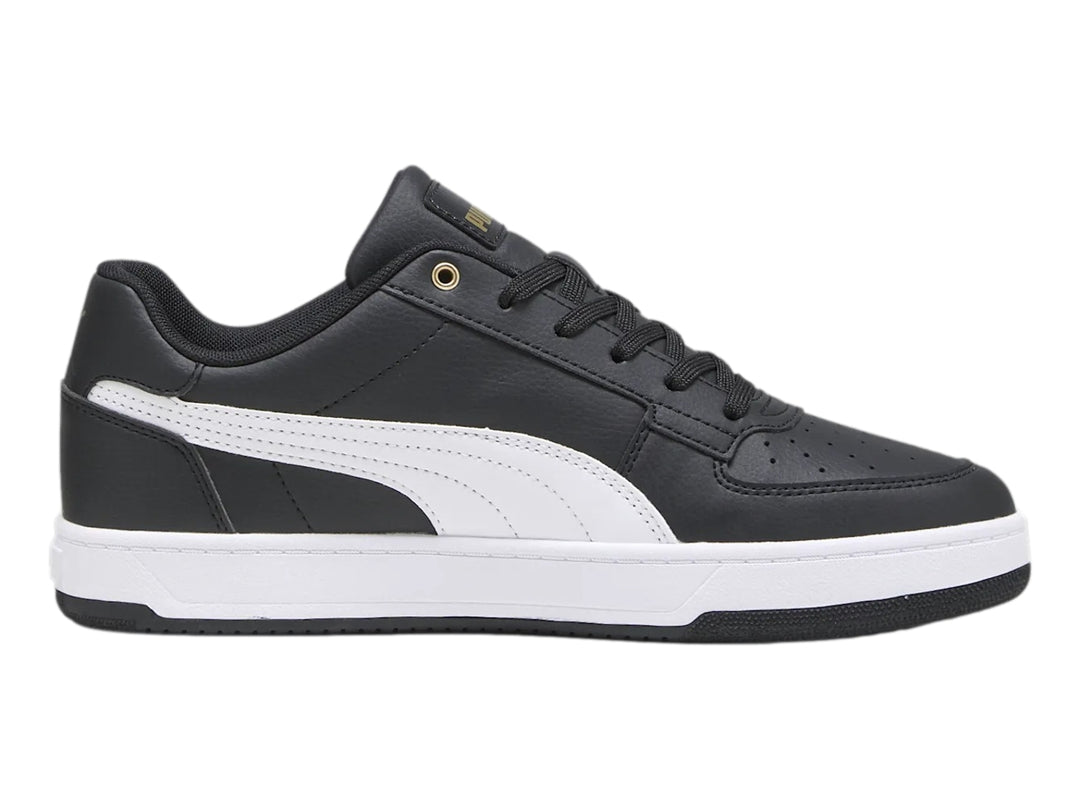 Tenis PUMA Caven 2.0 en color negro con franja lateral blanca y detalles dorados, suela blanca y negra.