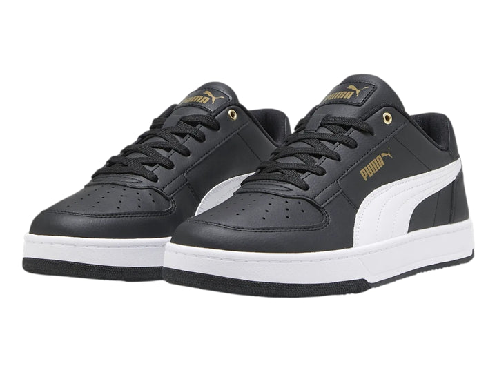 Tenis PUMA Caven 2.0 en color negro con franja lateral blanca y detalles dorados, suela blanca y negra.