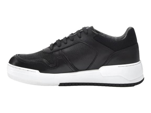 Tenis negros de cuero con suela blanca y cordones negros.