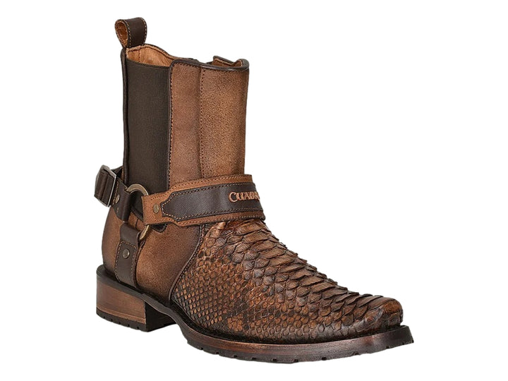 Bota de cuero color castaño con punta de piel de pitón y detalles de hebillas metálicas.