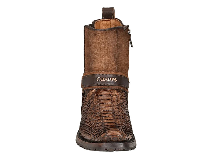 Bota de cuero color castaño con punta de piel de pitón y detalles de hebillas metálicas.