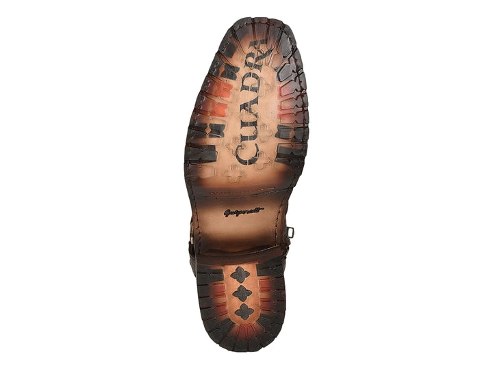 Bota de cuero color castaño con punta de piel de pitón y detalles de hebillas metálicas.