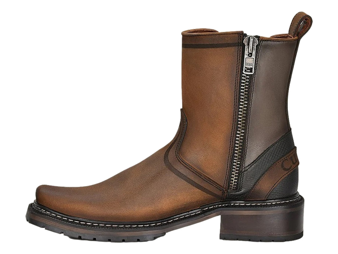 Bota chelsea de cuero color café con detalles en negro y suela robusta.