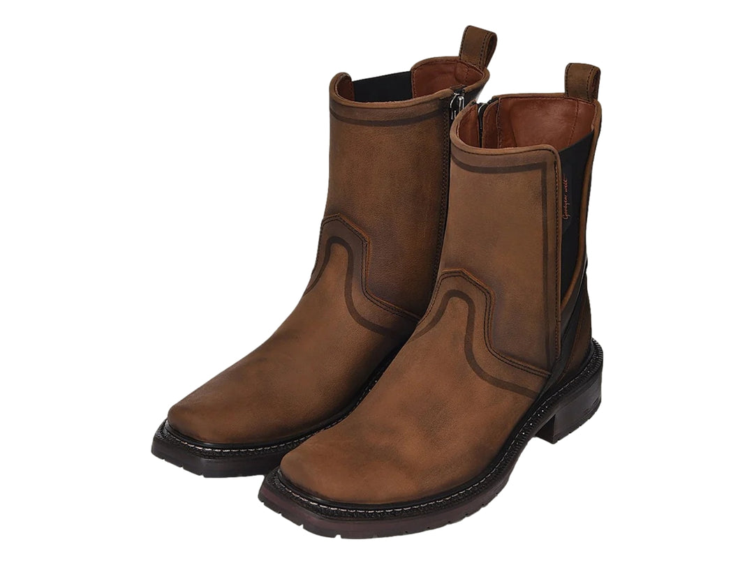 Bota chelsea de cuero color café con detalles en negro y suela robusta.