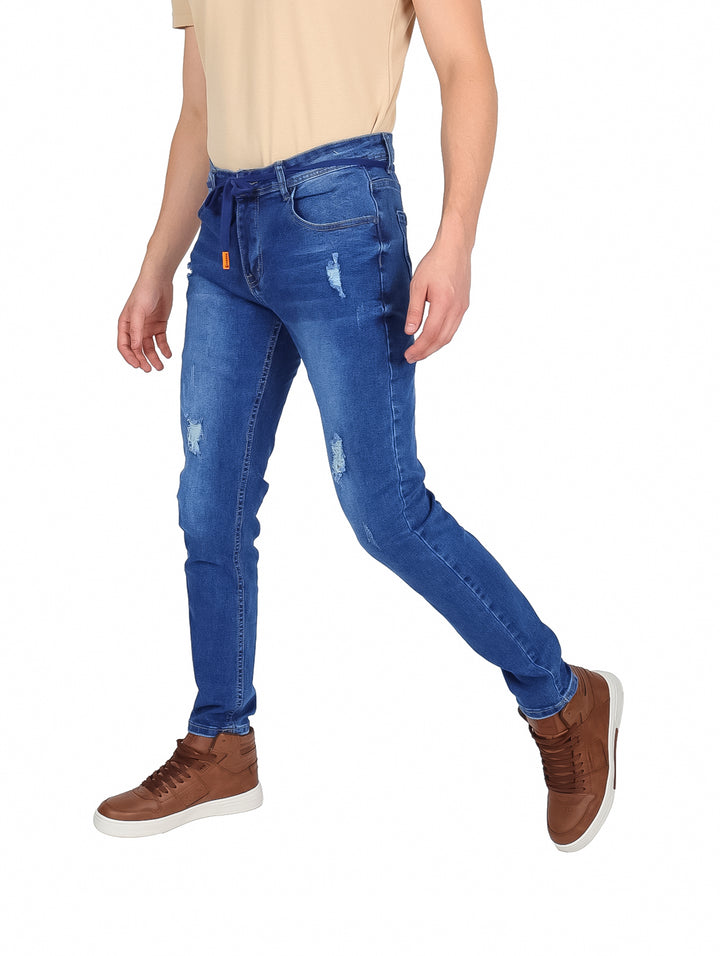 Hombre vistiendo pantalones jeans color azul con efecto desgastado y cintura ajustable.