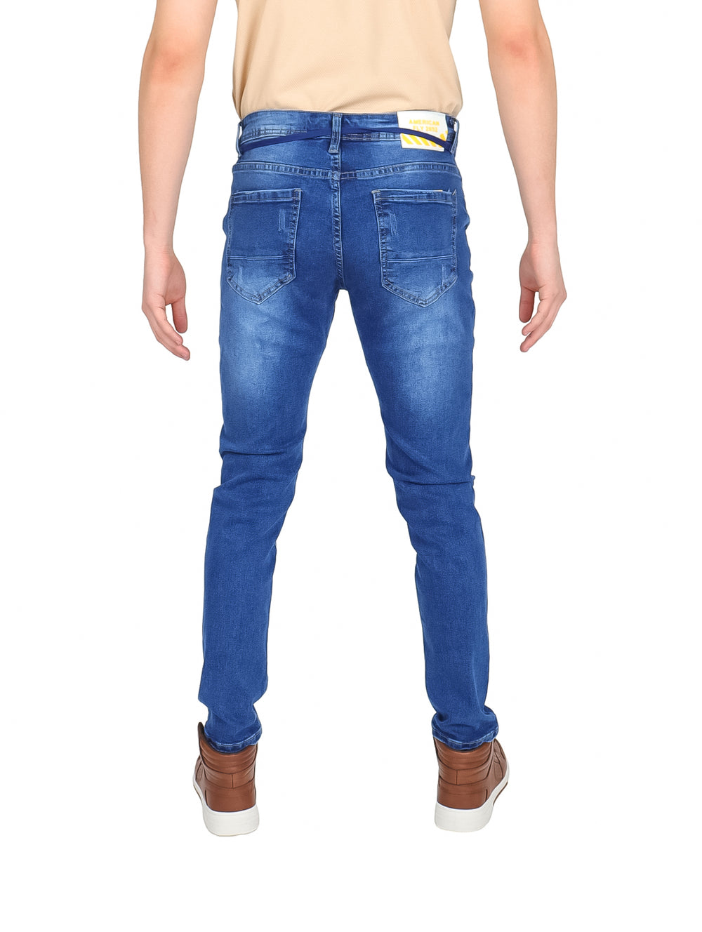 Hombre vistiendo pantalones jeans color azul con efecto desgastado y cintura ajustable.