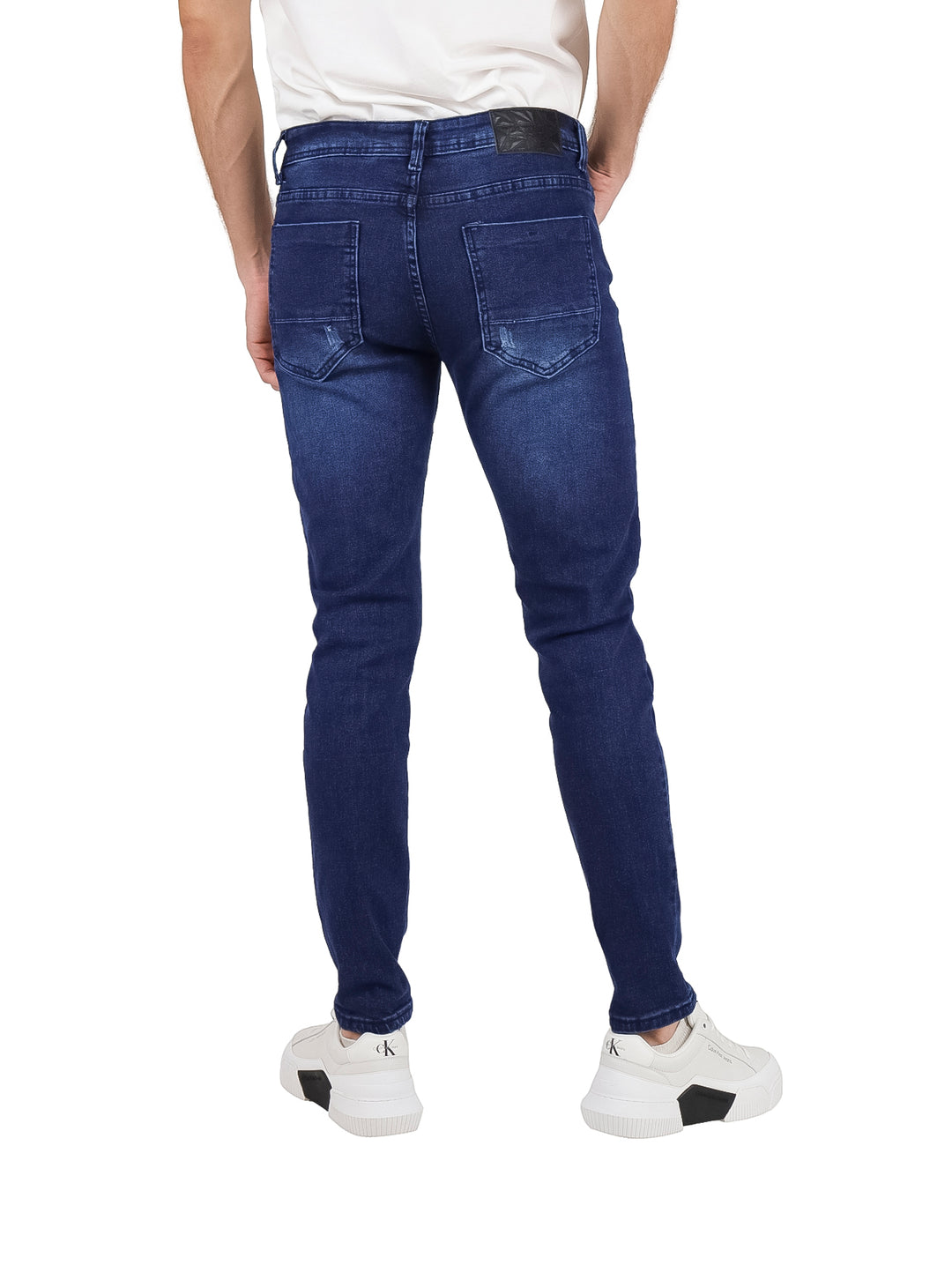 Pantalones jeans de mezclilla azul oscuro con corte ajustado.