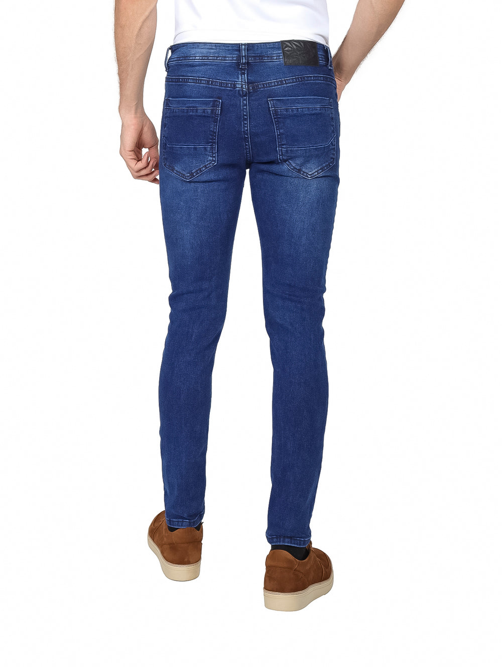 Hombre vistiendo pantalones jeans color azul con efecto de lavado stone wash y corte ajustado.