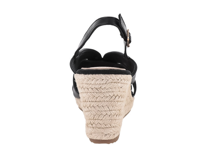 Sandalia de cuña color negro con plataforma de yute y correa ajustable con hebilla dorada.