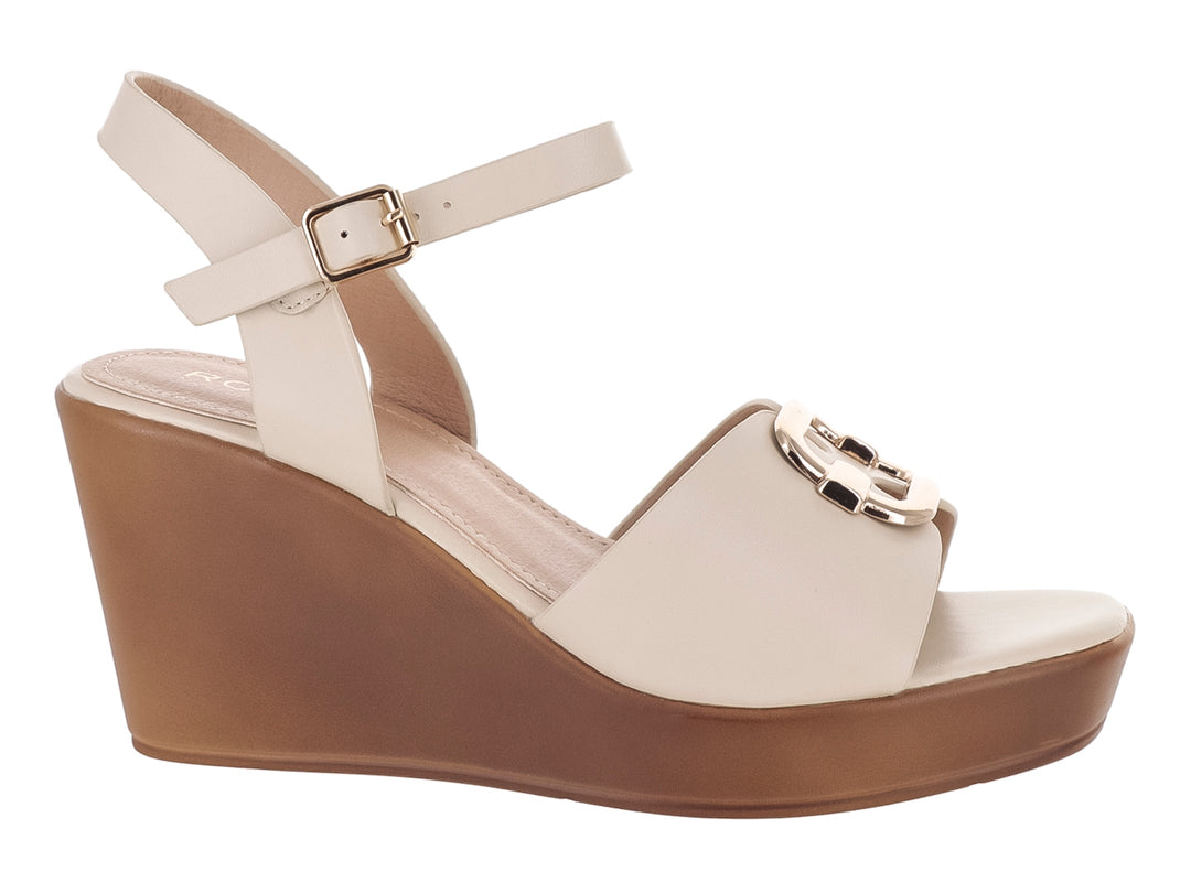 Sandalia de cuña color beige con plataforma marrón y detalles dorados.