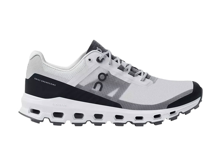 Tenis deportivos On Cloud color gris y blanco con suela blanca gruesa y detalles en gris oscuro.