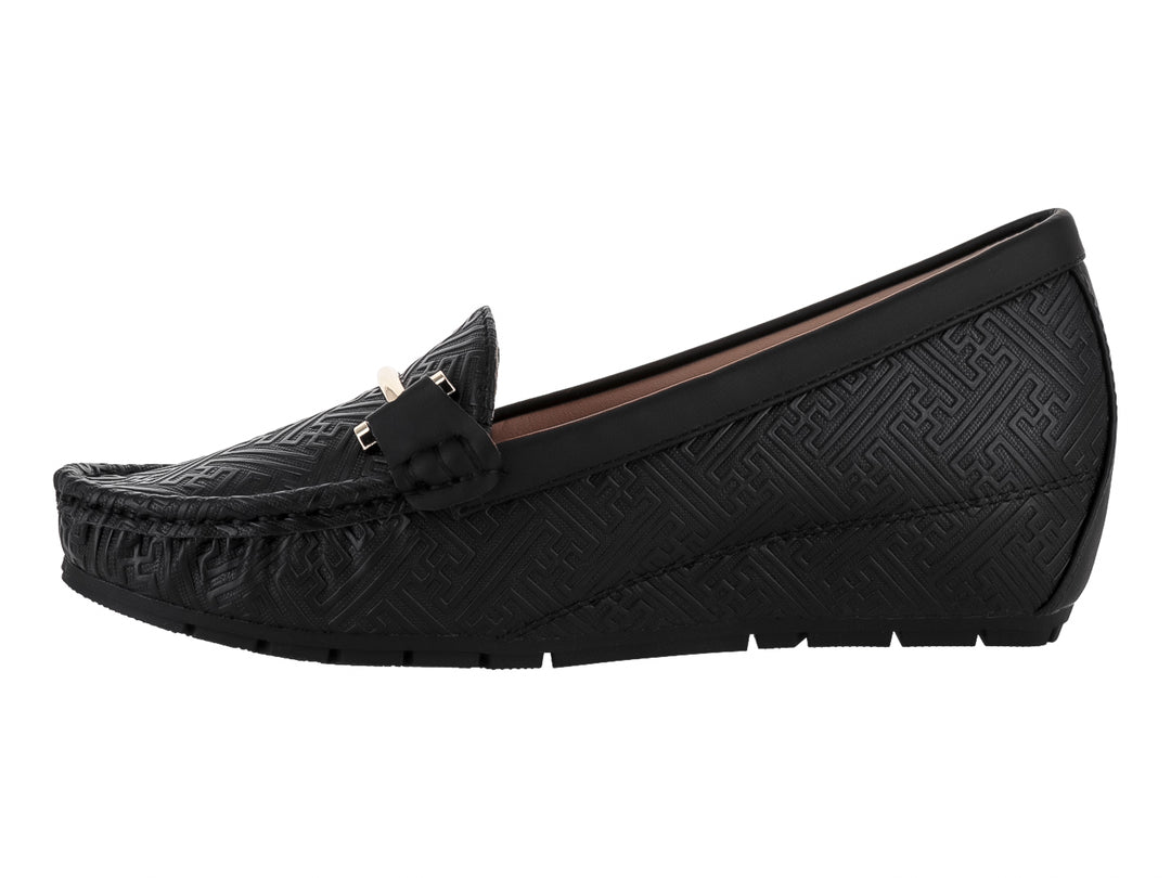 Zapato tipo mocasín color negro con textura grabada y detalle metálico dorado en la parte superior.