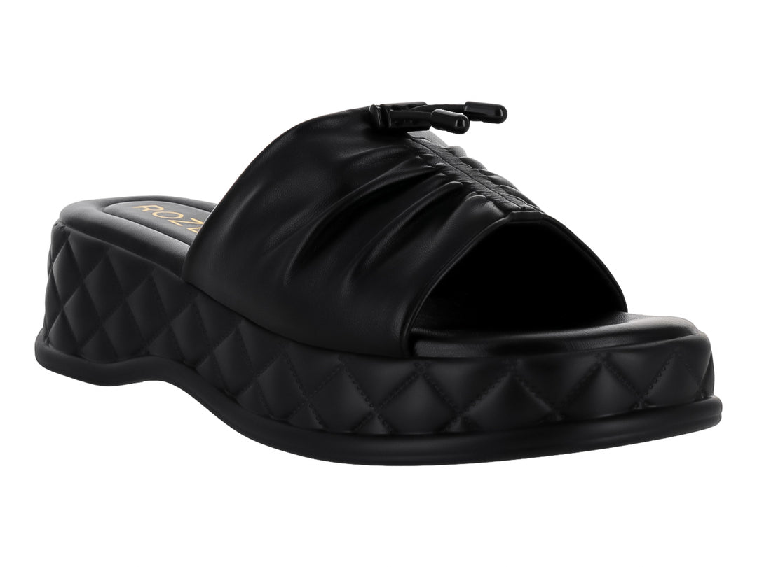 Sandalia de plataforma color negro con correa fruncida y suela con textura acolchada en forma de diamante.