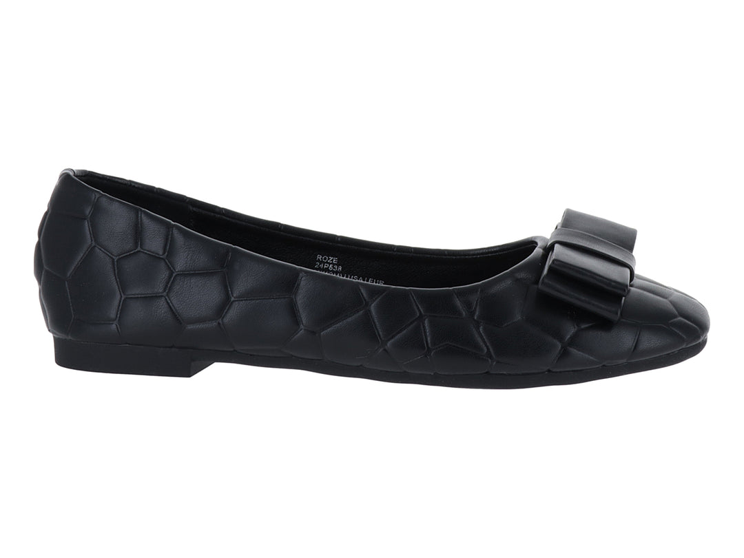 Zapato plano color negro con textura en relieve y un moño decorativo en la parte frontal.