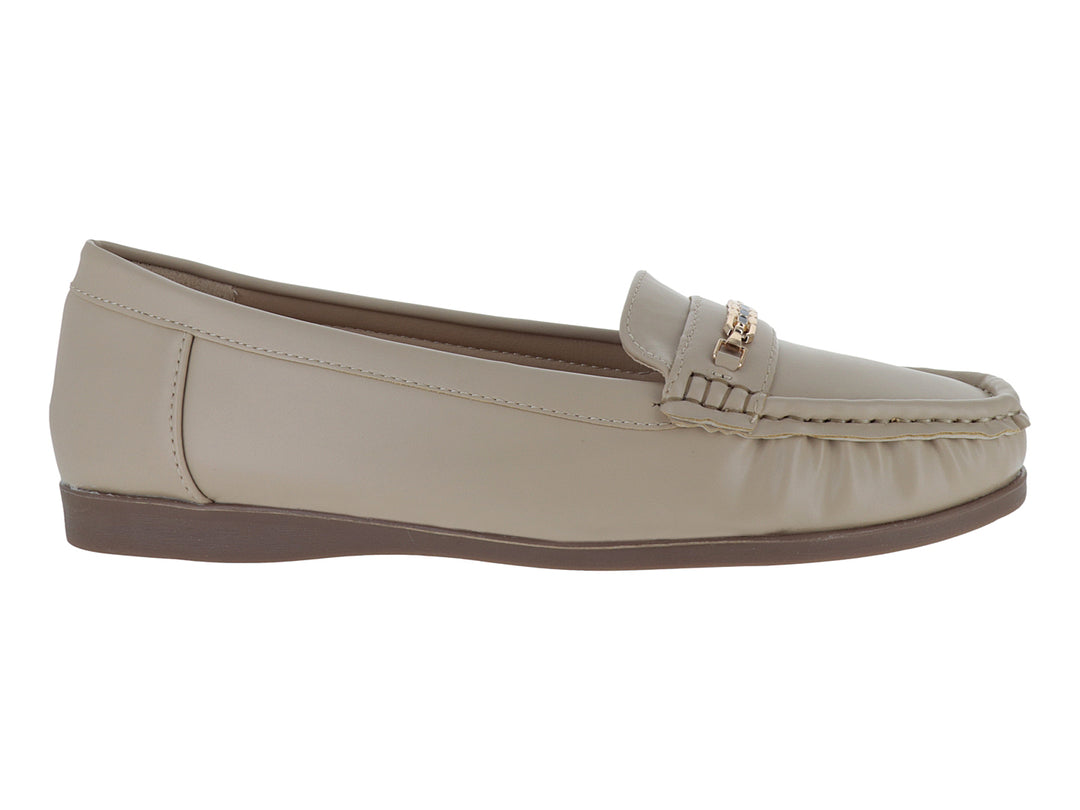 Zapato tipo mocasín color beige con adorno dorado en la parte superior y suela marrón.