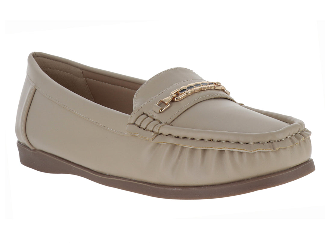 Zapato tipo mocasín color beige con adorno dorado en la parte superior y suela marrón.