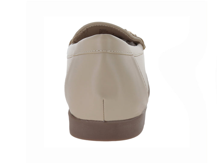 Zapato tipo mocasín color beige con adorno dorado en la parte superior y suela marrón.
