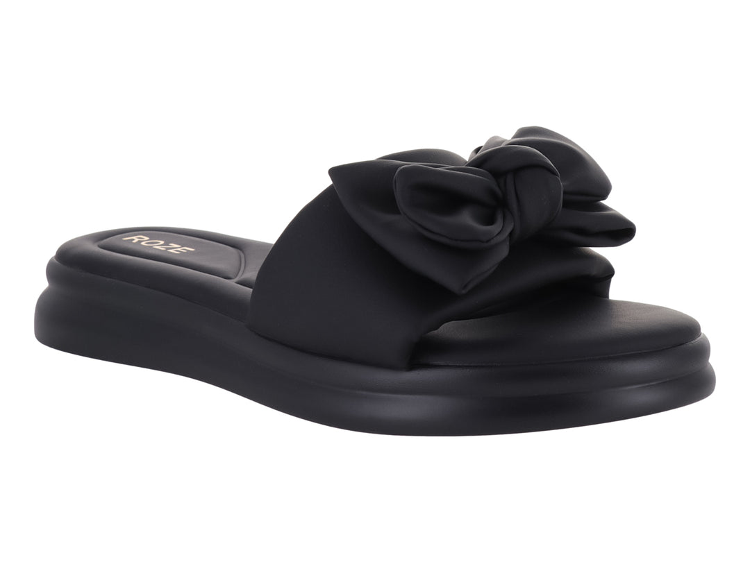 Sandalia slide color negro con correa de volantes y suela de plataforma gruesa.