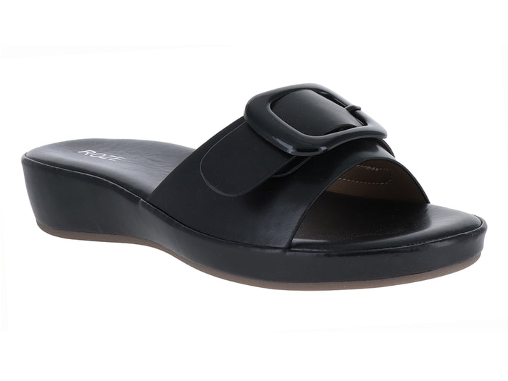Sandalia negra de plataforma con hebilla decorativa y suela cuña.