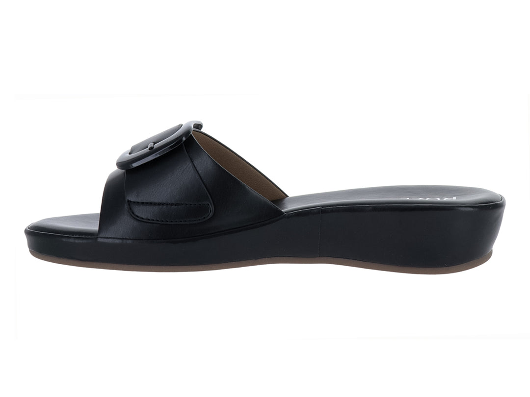 Sandalia negra de plataforma con hebilla decorativa y suela cuña.