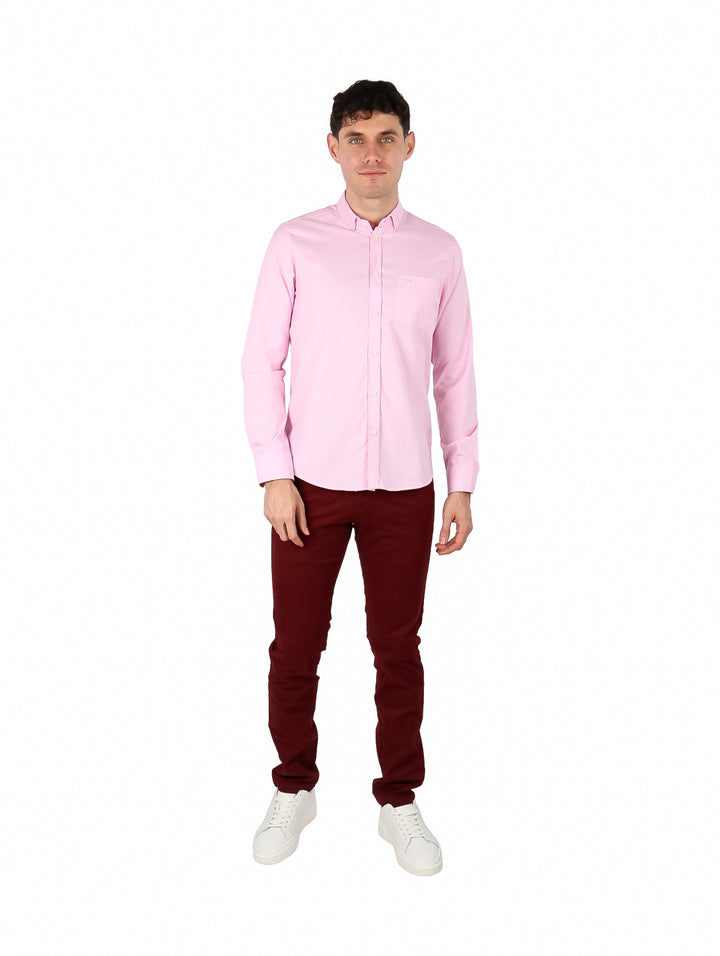 Hombre vistiendo una camisa Oxford de color rosa claro con manga larga y botones.