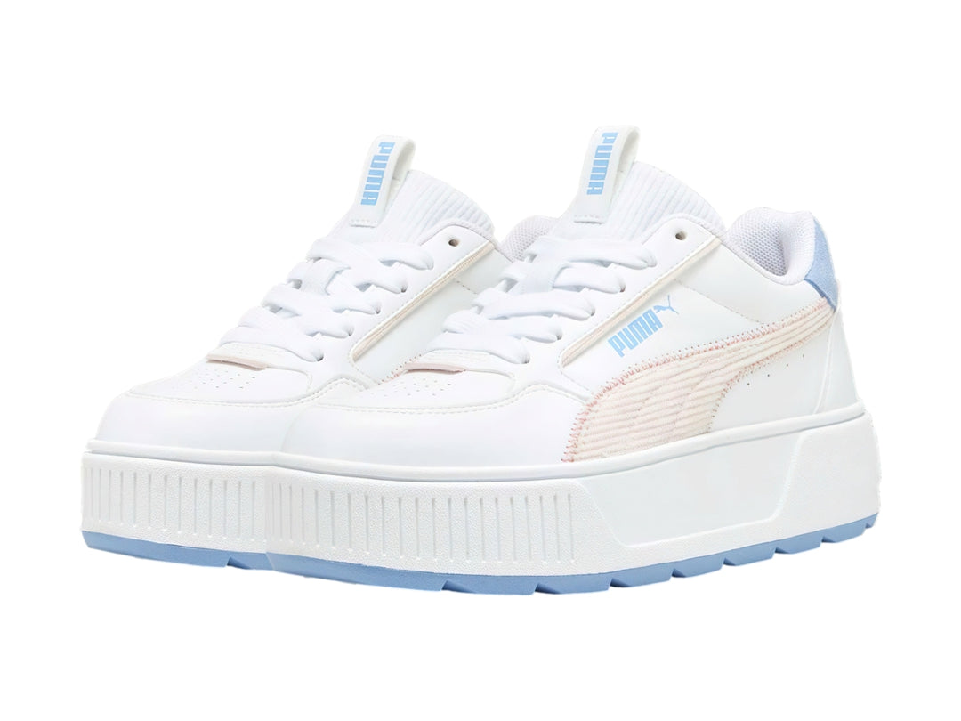 Tenis PUMA blancos con detalles en rosa y azul, suela de plataforma blanca y diseño deportivo para niños.
