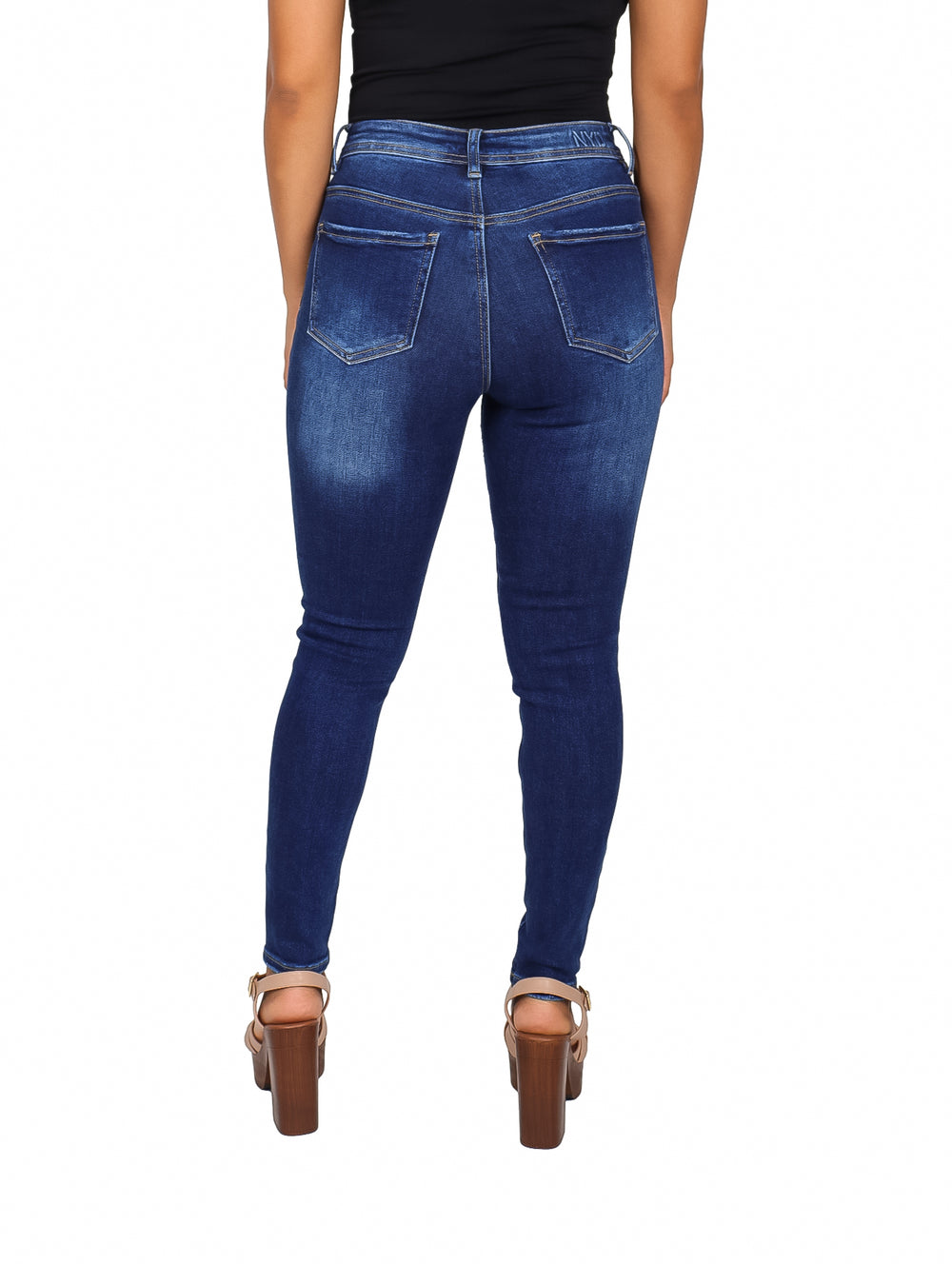 Jeans ajustados para mujer en color azul oscuro con roturas decorativas en las rodillas.