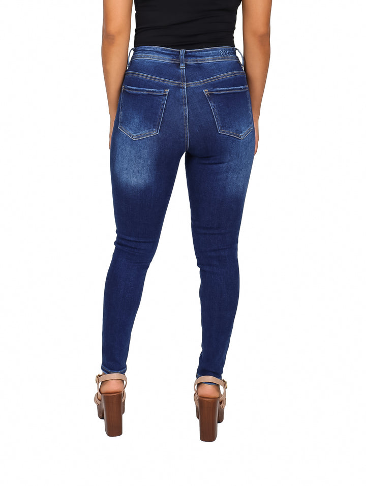 Jeans ajustados para mujer en color azul oscuro con roturas decorativas en las rodillas.