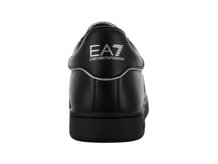 Tenis negros de cuero Emporio Armani con logotipo EA7 en dorado en el lateral.