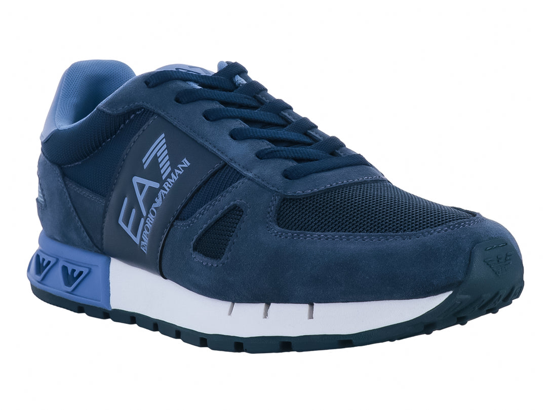 Tenis Emporio Armani en tonos azul con suela blanca y detalles en gamuza y tela.