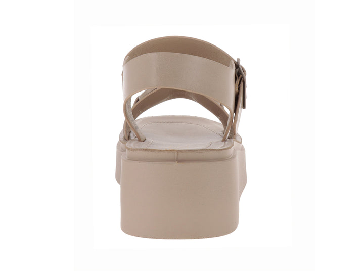 Sandalias de plataforma color beige con correa ajustable al tobillo y detalle de hebilla en la parte frontal.