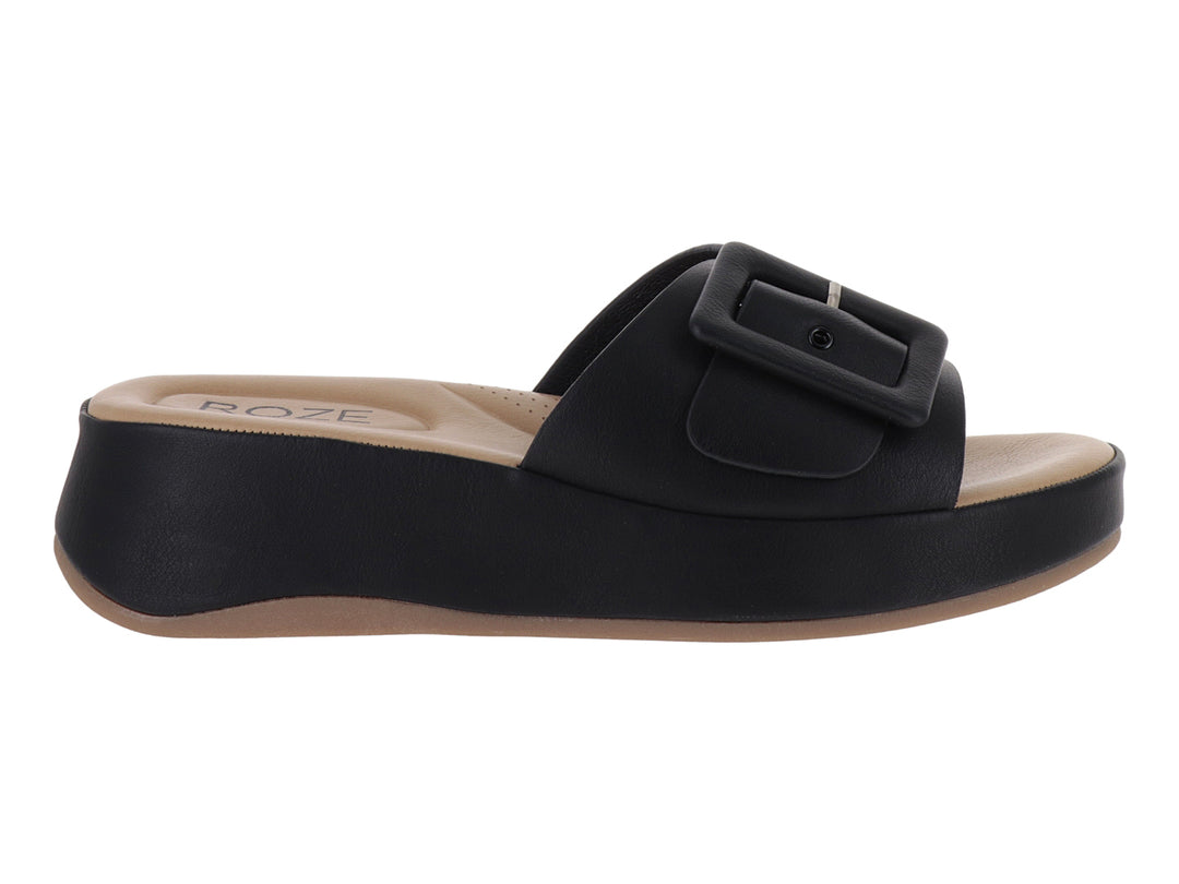 Sandalia de plataforma color negro con hebilla decorativa y planta en tono beige.