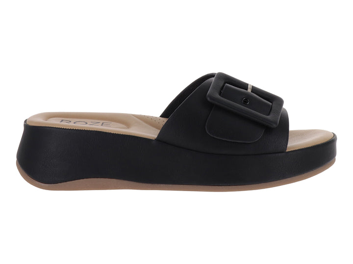Sandalia de plataforma color negro con hebilla decorativa y planta en tono beige.