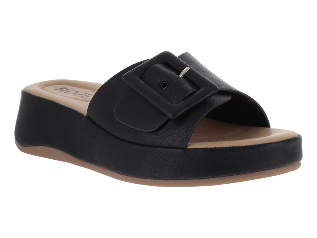 Sandalia de plataforma color negro con hebilla decorativa y planta en tono beige.