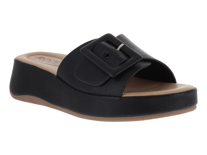 Sandalia de plataforma color negro con hebilla decorativa y planta en tono beige.