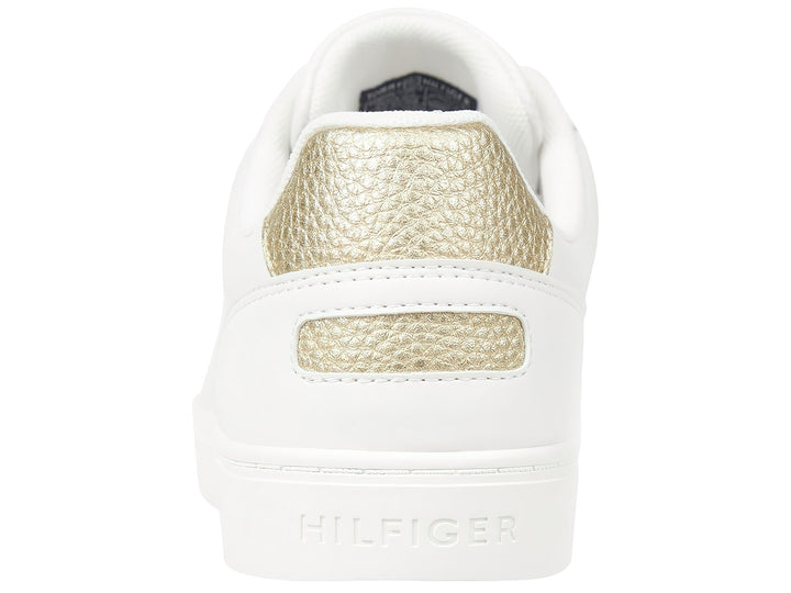 Tenis Tommy Hilfiger color blanco con detalle dorado en el talón y suela blanca.