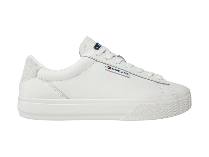 Tenis Tommy Hilfiger color ecru con suela de plataforma y detalle gris en el talón.
