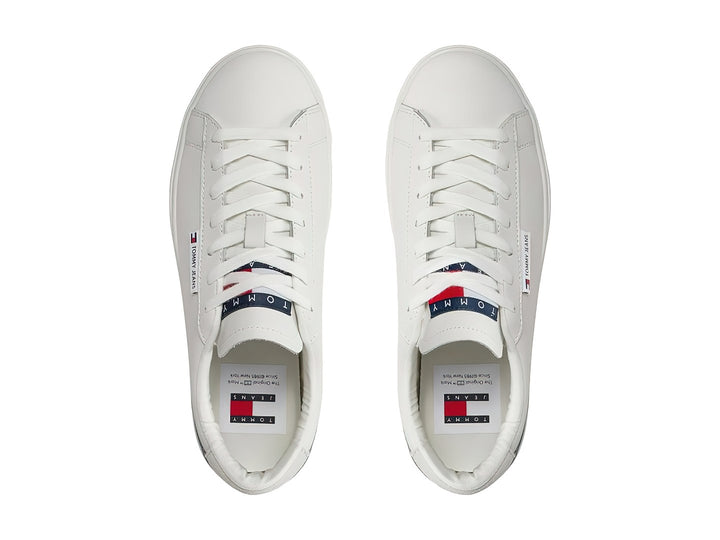 Tenis Tommy Hilfiger color ecru con suela de plataforma y detalle gris en el talón.