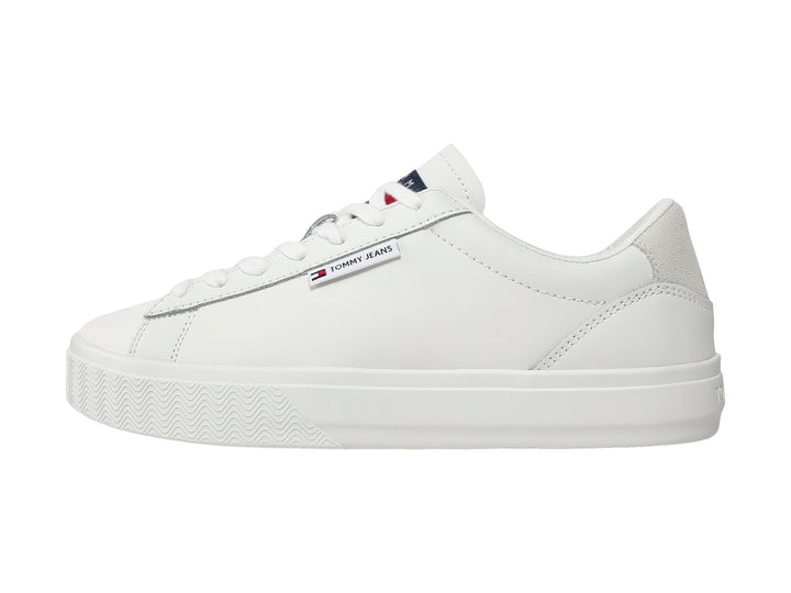 Tenis Tommy Hilfiger color ecru con suela de plataforma y detalle gris en el talón.