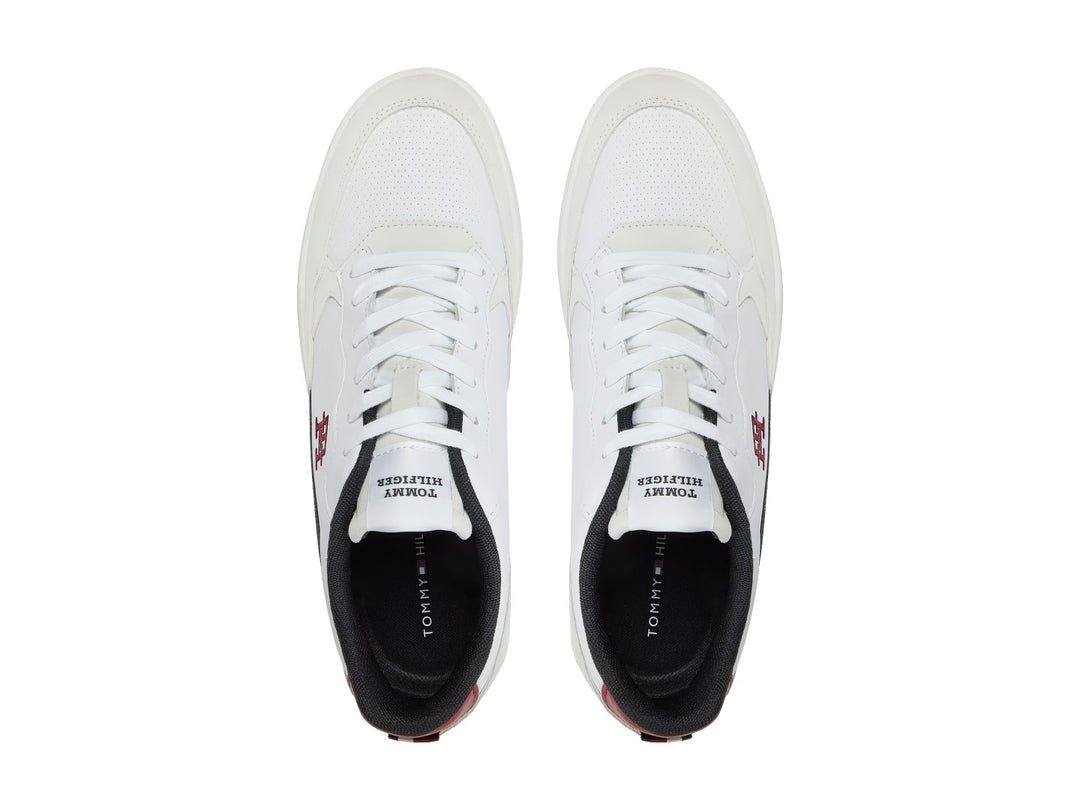 Tenis blancos Tommy Hilfiger con detalles en gris y azul marino y suela blanca.
