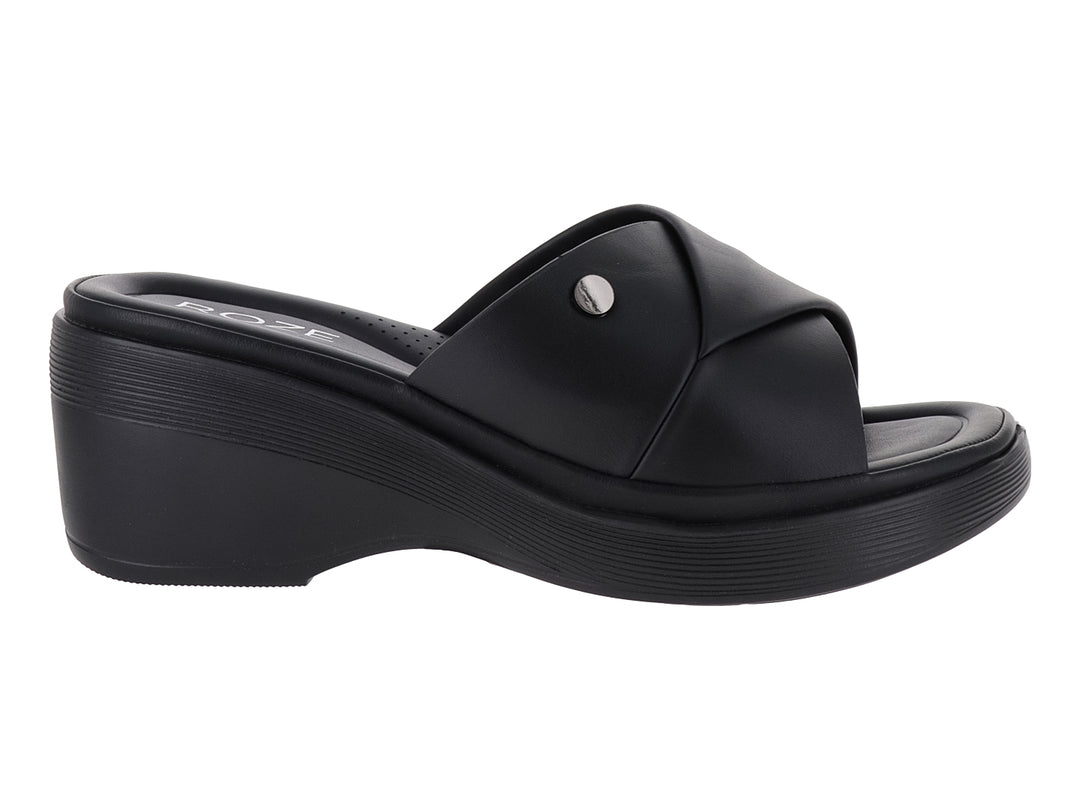 Sandalia de plataforma color negro con diseño de tira cruzada y detalle metálico.