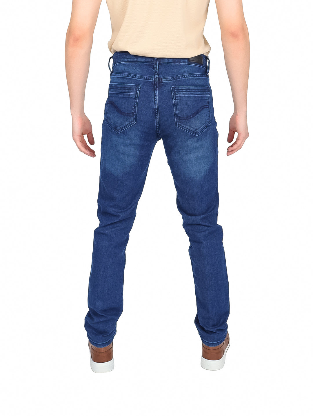 Hombre vistiendo pantalones slim jeans color azul, camiseta beige y tenis cafés.