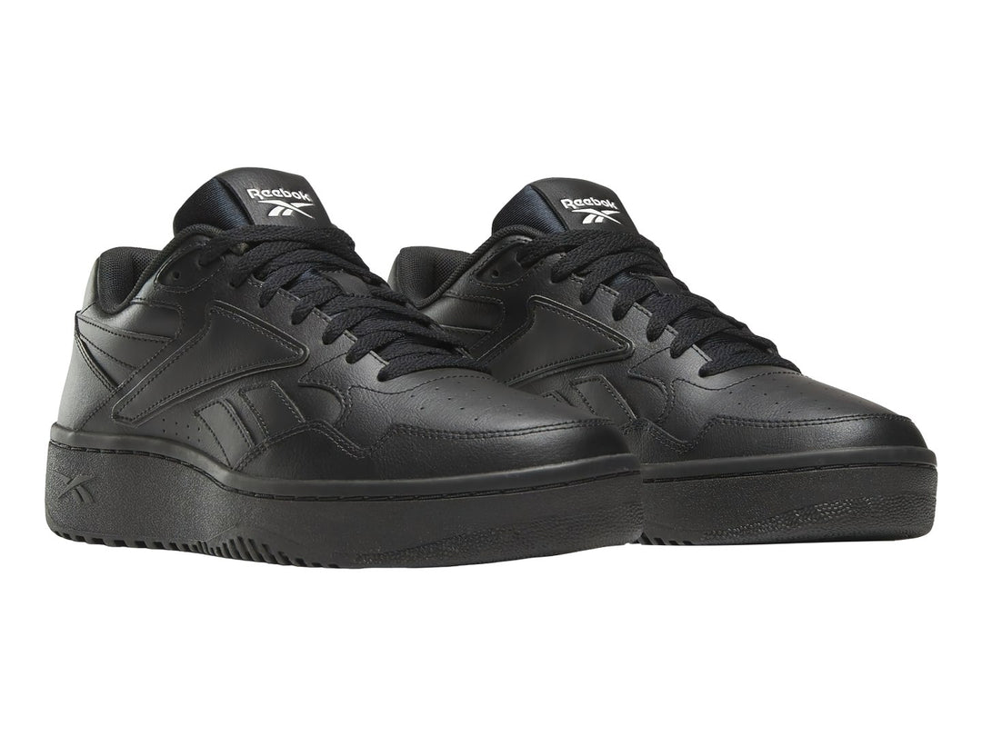 Tenis deportivos Reebok color negro total con suela ancha y diseño clásico.