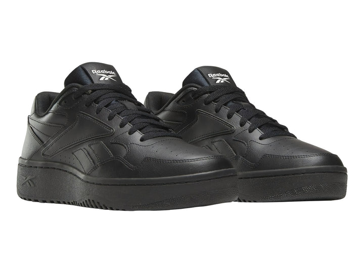 Tenis deportivos Reebok color negro total con suela ancha y diseño clásico.